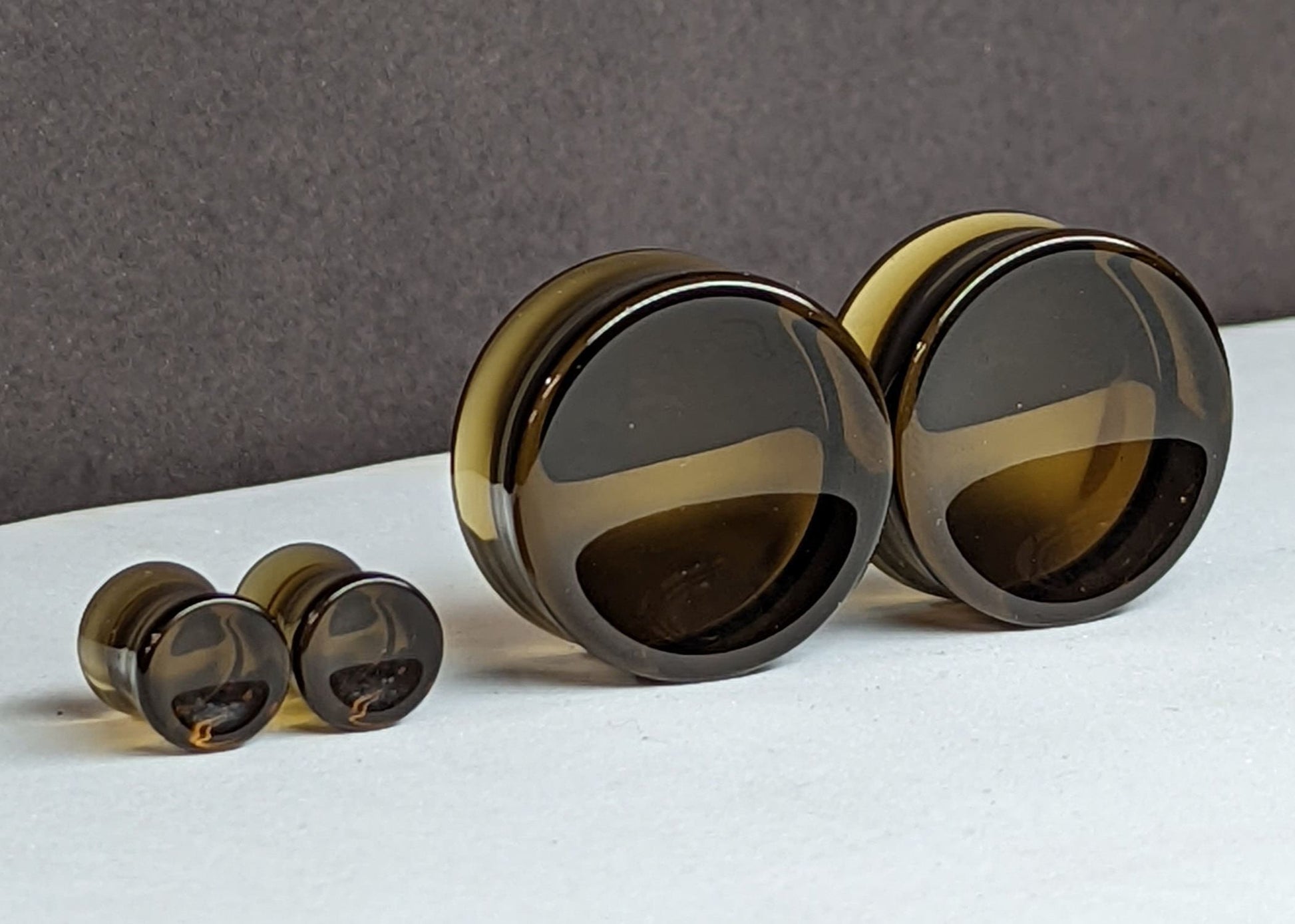 Concave Brown Glass Plugs for stretched ears.
