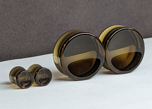 Concave Brown Glass Plugs for stretched ears.