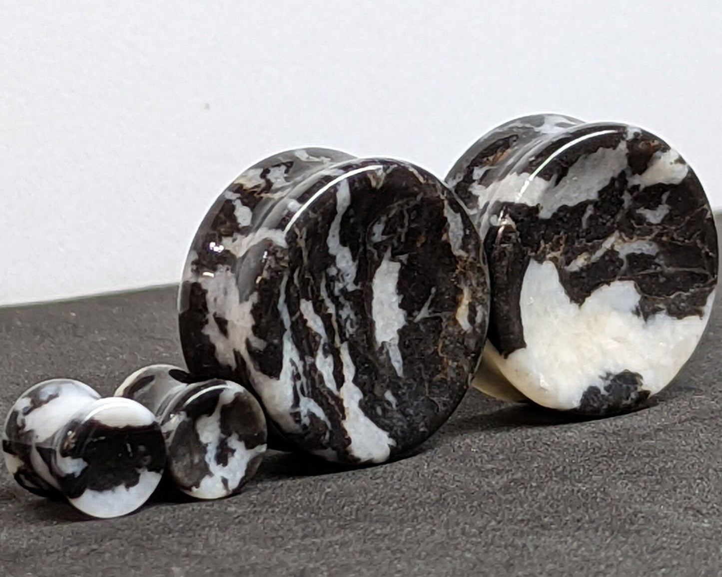 Concave Zebra Stone Plugs for stretched ears.